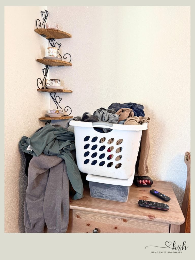 4-Week January Cleaning Schedule With Printable 3 A laundry basket and piles of clothes sit atop a wooden dresser for a January cleaning schedule task.