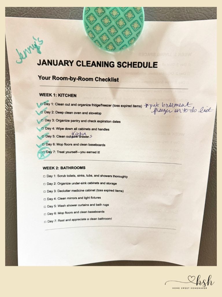 4-Week January Cleaning Schedule With Printable 4 A paper titled January cleaning schedule is pinned to a fridge, showing completed kitchen tasks and handwritten notes.