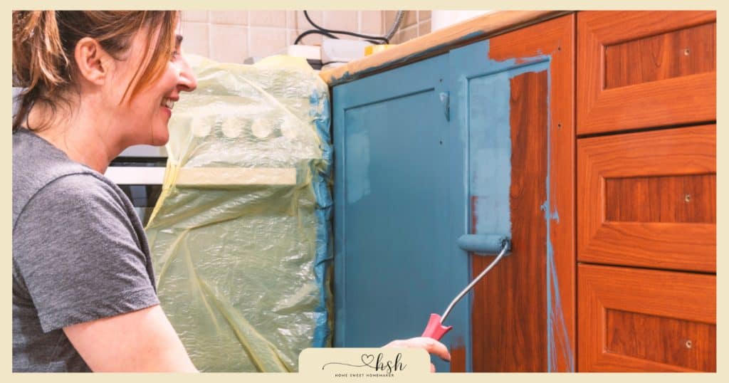 Woman painting wooden furniture blue with roller brush showing DIY home resolutions for new year makeover projects.