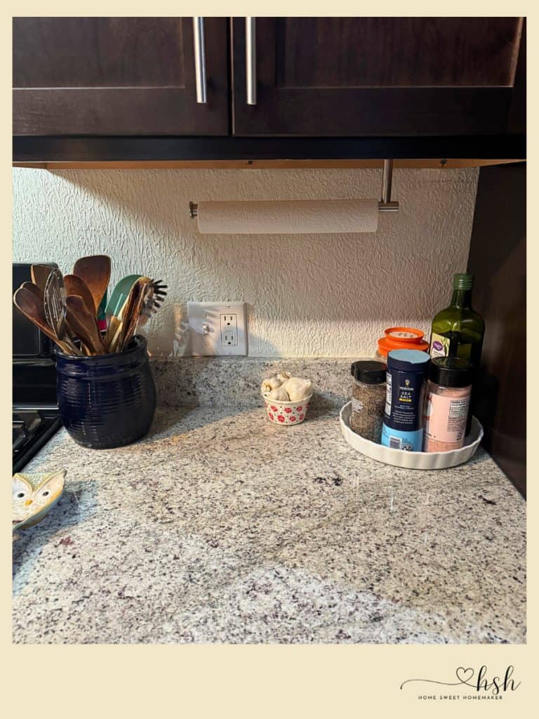 How to Organize a Small Kitchen on a Budget | Complete Guide 9 Clean kitchen counter with utensil crock, under-cabinet paper towel holder, and lazy Susan organizing frequently used cooking essentials in small space.