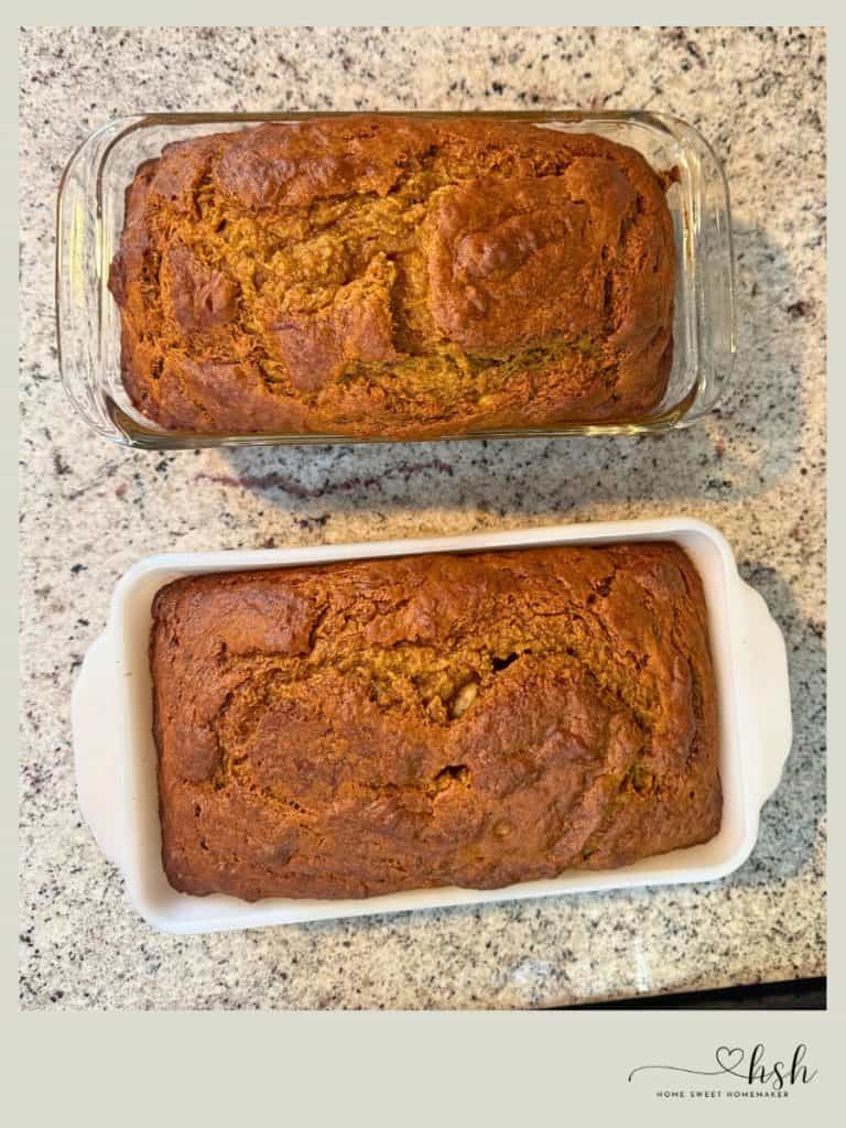 Two golden brown pumpkin banana bread loaves fresh from oven in glass and ceramic pans
